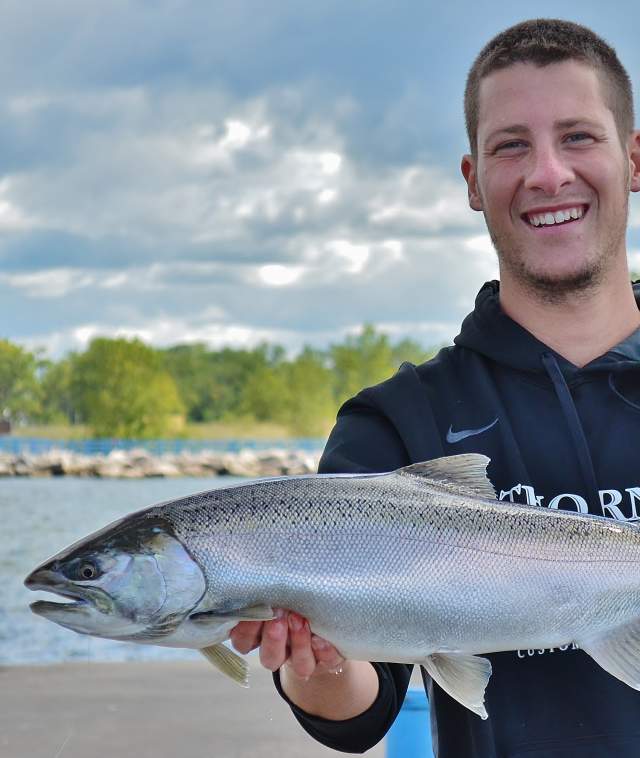 Man holding fresh caught fish with big red in the background