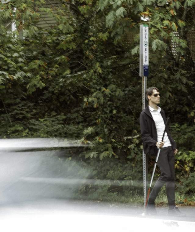 man waiting by a bus stop