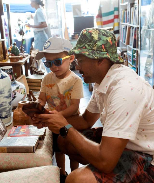 A relaxed moment inside a Nanaimo vintage shop, where an adult and child explore together among shelves of unique antiques and collectibles.