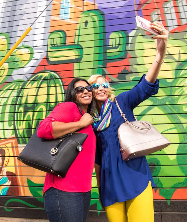 Friends pose for a selfie in front of a mural at SanTan Brewing Co. in Chandler, AZ