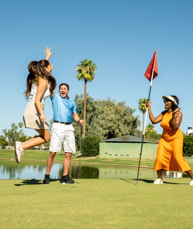 Group jumping and cheering at golfer who putted golf ball into the hole on the San Marcos Golf Course.