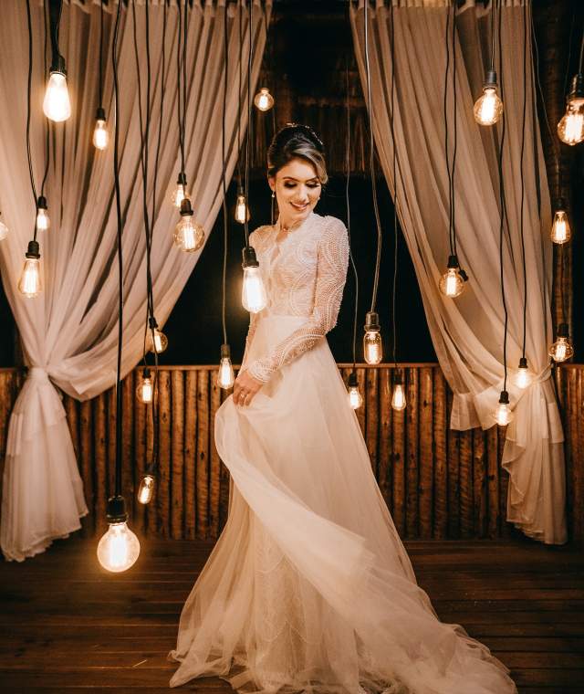Bride in wedding gown among hanging lights