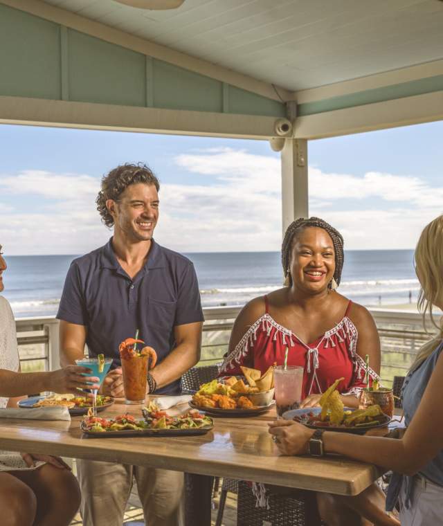 A group of friends dines oceanfront at Snooky's on the Water