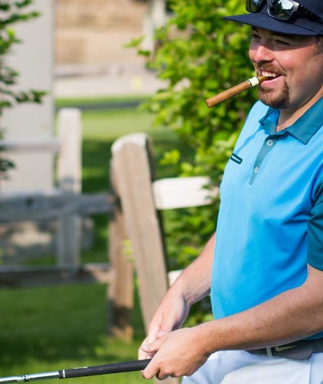 Man golfing with a cigar