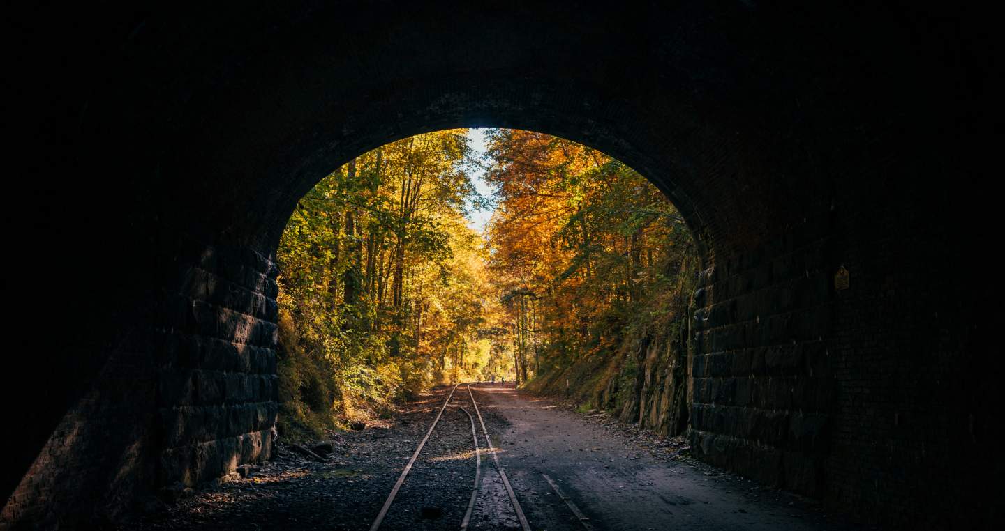 Looking out of the Howard Tunnel at the bright autumn foliage along the rail trail