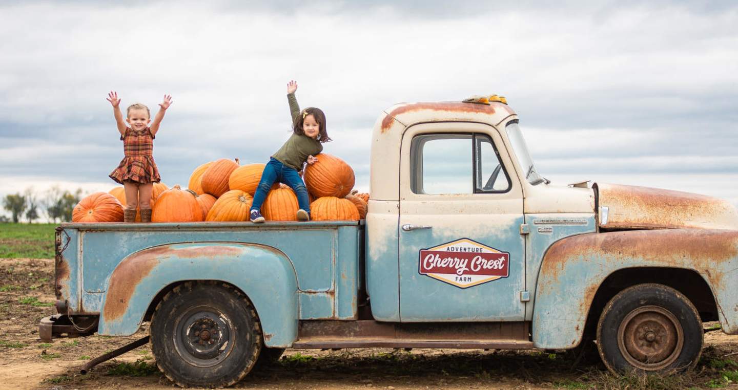 children in back of vintage truck with pumpkins at Cherry Crest Adventure Farm