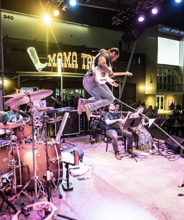 Mama Tried musician jumping on outdoor stage