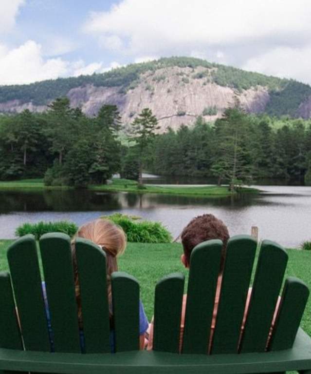 people in chairs facing lake