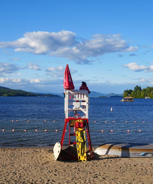 Lifeguard chair on the beach facing Lake George and Adirondack Mountains