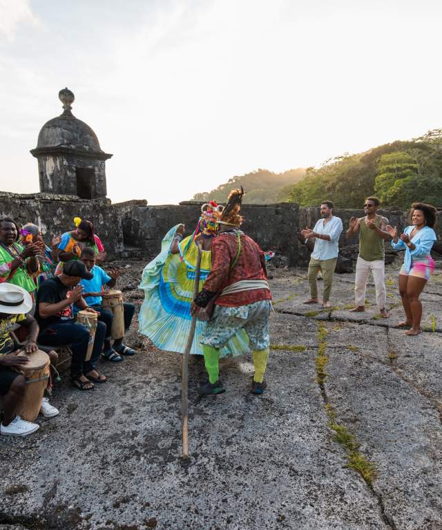Group of Congos dancing wearing colorful polleras outside Fuerte San Fernando at Portobelo, Colon province
