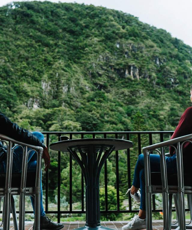 Couple drinking coffee on a terrace. The mountains of Cerro Punta are on the view
