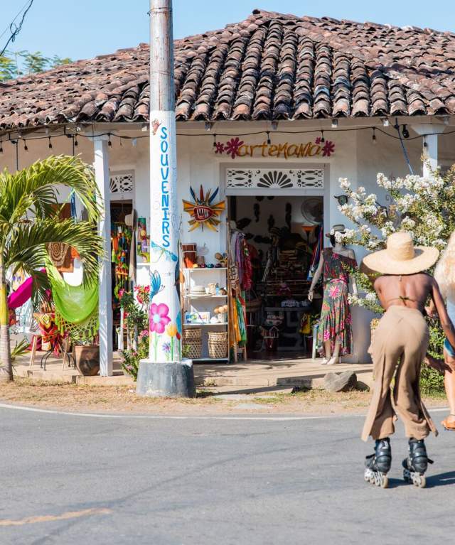 Friends riding bicycle and roller skates near a colonial house in Pedasi, Los Santos