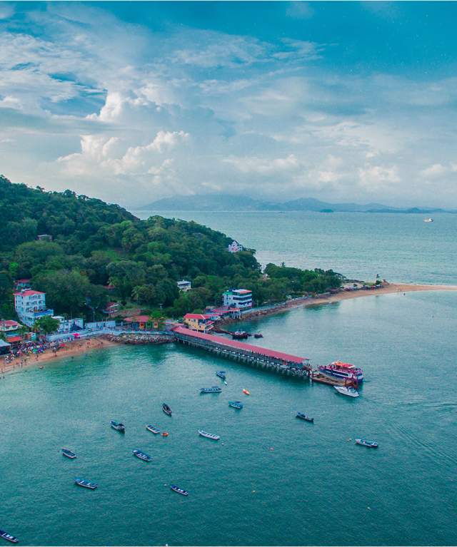 Aerial view of the town of San Pedro on Taboga Island, featuring the pier, beach, and tropical vegetation, Panama.
