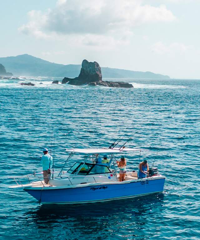 Sportfishing boat in Panamá’s coastal waters, with a mountainous landscape in the background and open sea ideal for world-class fishing