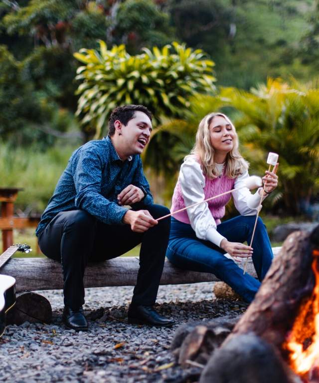 Couple roasting marshmallows beside an outdoor campfire in Boquete, Panama.