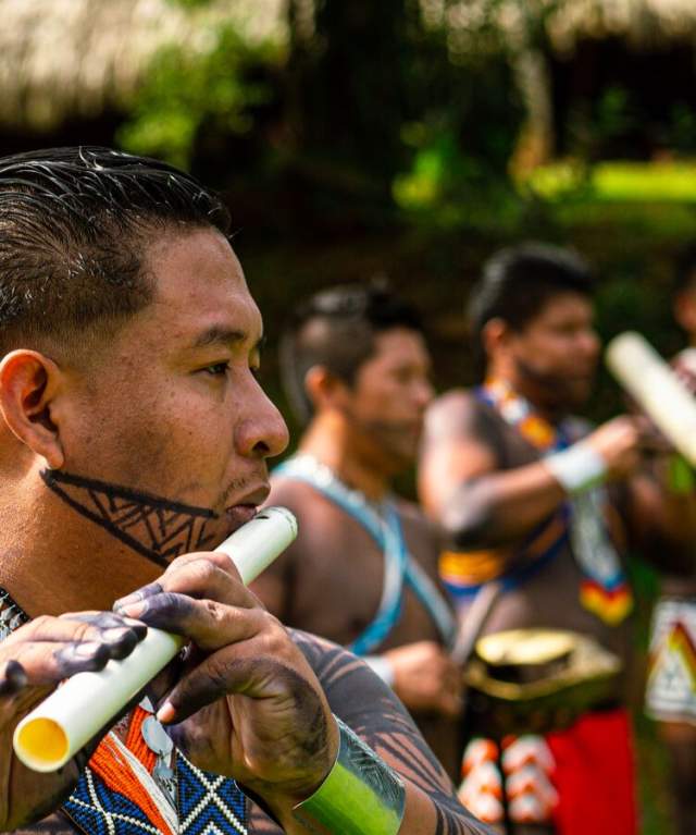 Embera playing typical music, dressed with colorful clothes