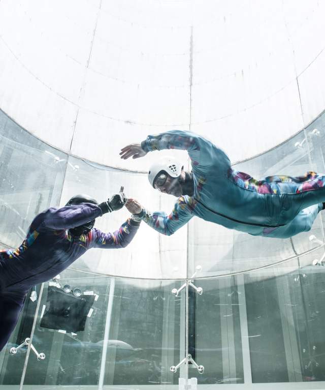 Two indoor skydivers in a wind tunnel in Perris, CA