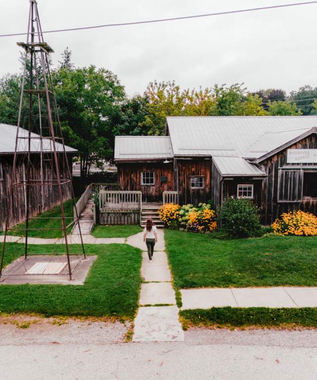 A visitor walks down the sidewalk leading to an 1800s replica cheese factory