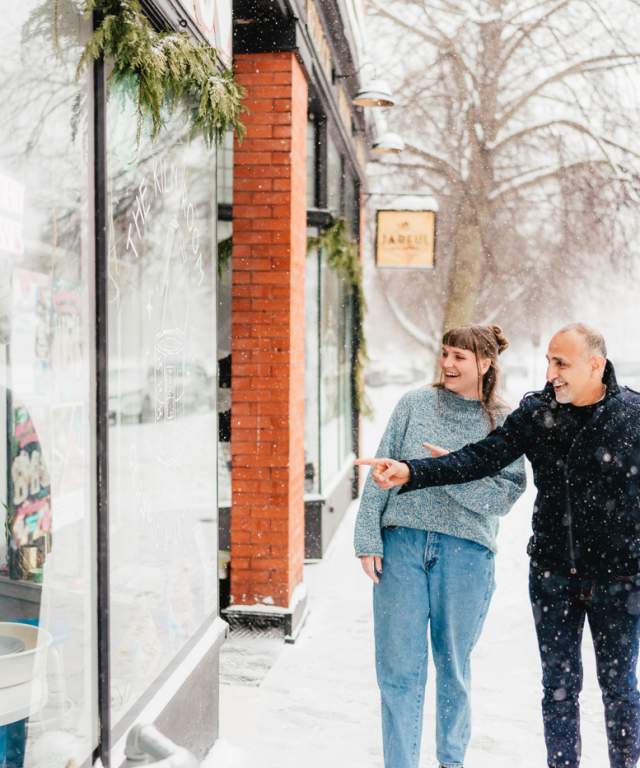 group of three friends walking in winter past storefront window