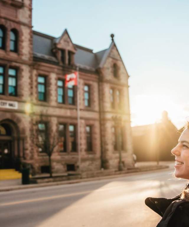 Happy woman in front of a building