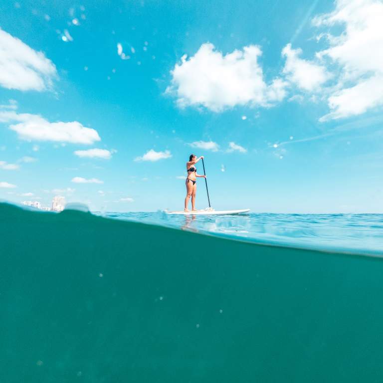 A woman stand-up paddleboarding on the ocean in Fort Lauderdale, FL