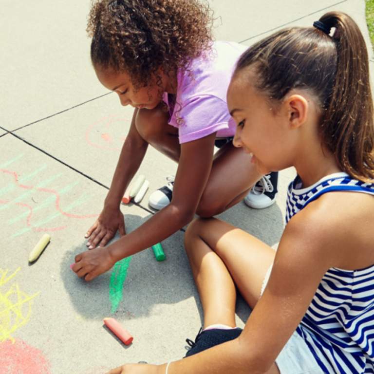 Girls drawing with chalk at Science Central in Fort Wayne. World Art Day is April 18, 2026.