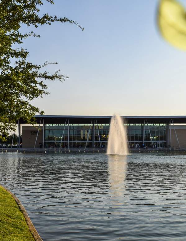 Event Center With Body Of Water And Tree Lined Path