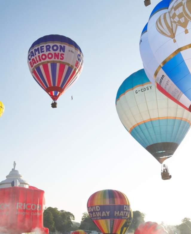 A group of balloons lifting off in a mass ascent at Bristol International Balloon Fiesta - credit Paul Box