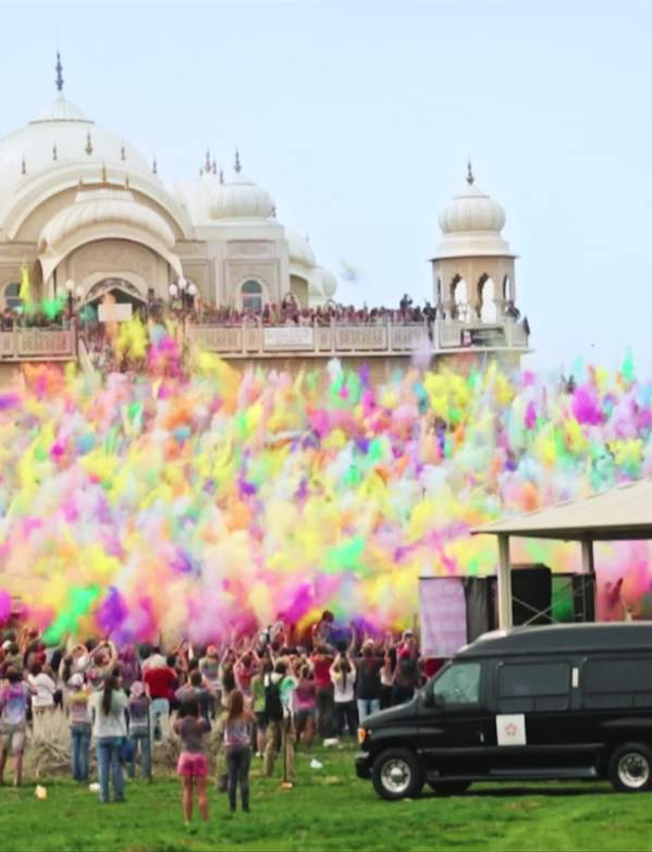 Large group of people throwing colorful chalk at the Krishna Temple in Spanish Fork for the Holi Festival of Colors