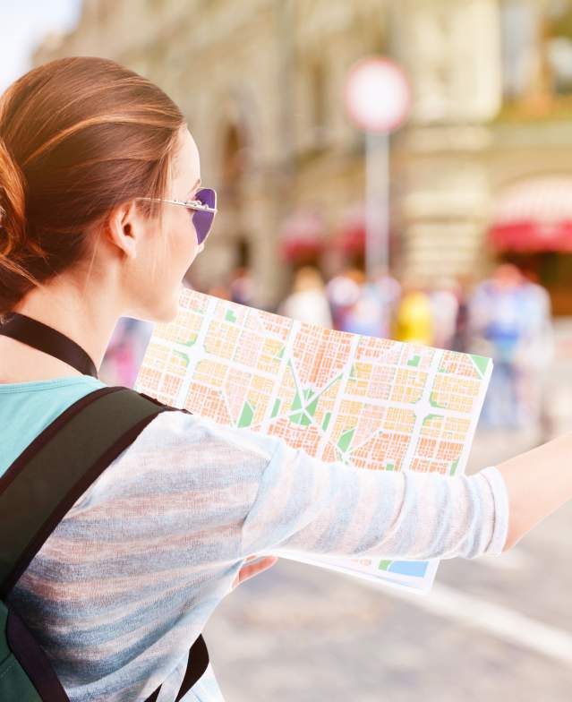 Woman reading map and pointing to her right