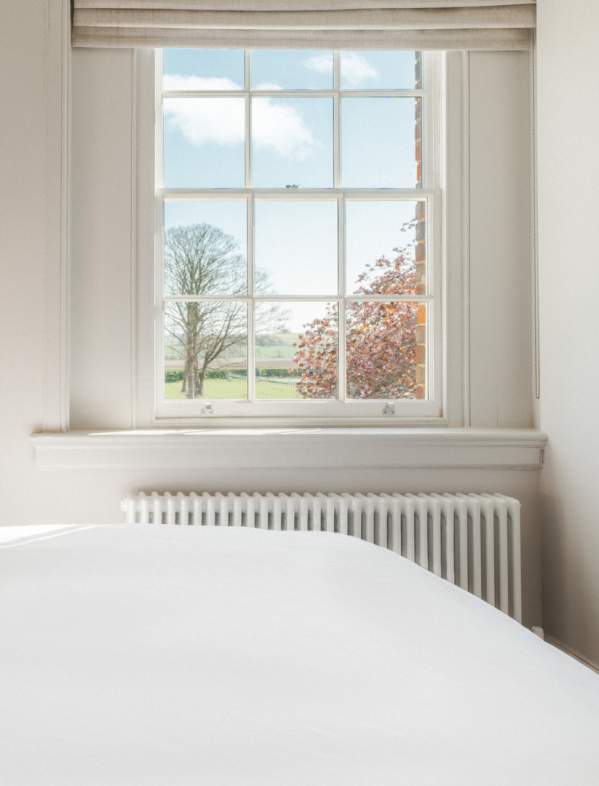 Indoor shot of double bed in bedroom with picturesque view through window taken at Constantine House