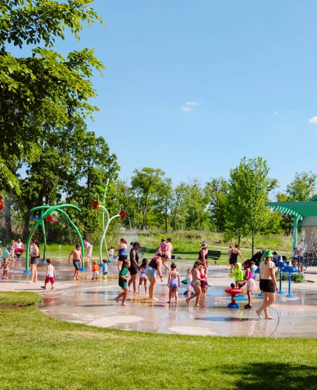 Splash Pad on a warm, sunny day with kids playing in the outdoor water structures.