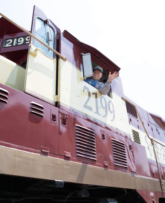 Train Conductor waiving on train