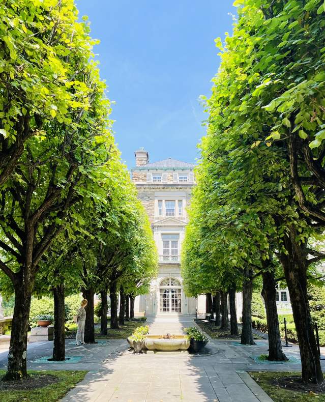 Lush green trees line a pathway in the gardens behind Kykuit, The Rockefeller Estate.