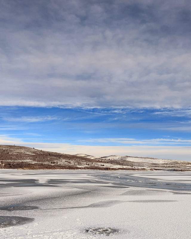 A fisherman stands on ice at Panguitch Lake in Utah.