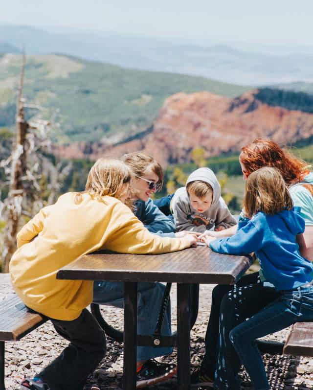 people sitting at picnic table outside  at brian head in the summer