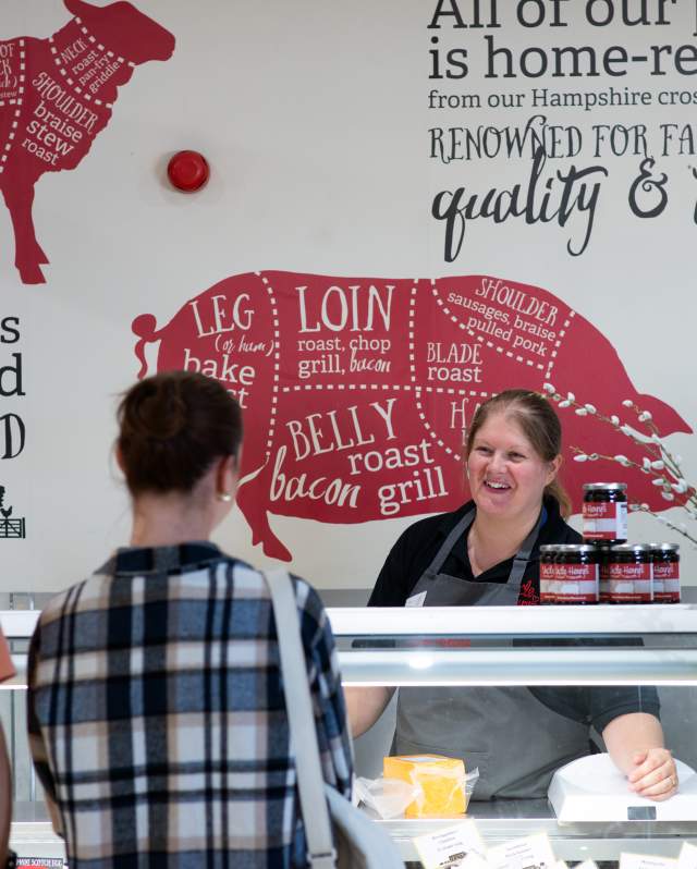 Uncle Henry's farm shop meat counter with two people speaking to a server over the counter.