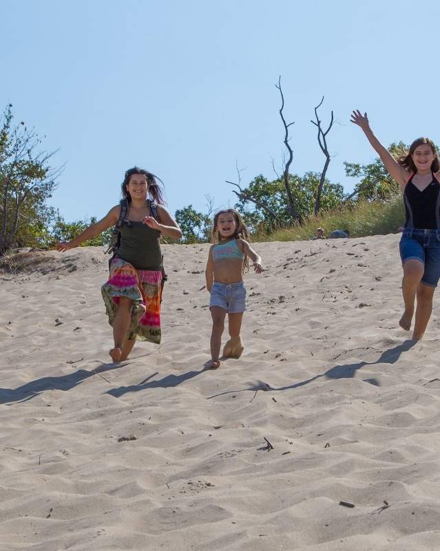 Family running down a beach dune