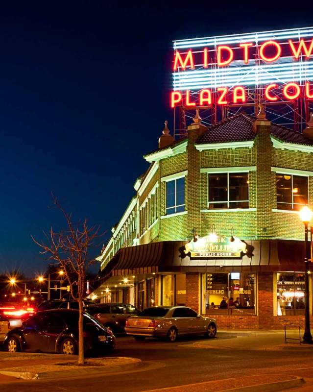 Exterior of Midtown's Plaza Court neon sign and McNellie's at night