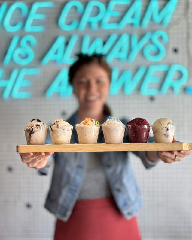 Woman holding ice cream flight at Boom Town Creamery