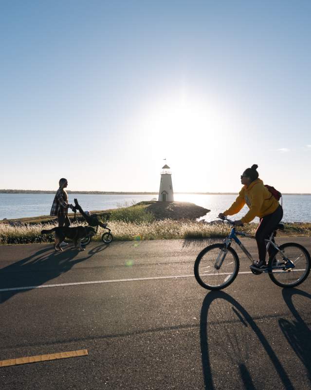 Person riding bike along lakeside trail in Oklahoma City at Lake Hefner