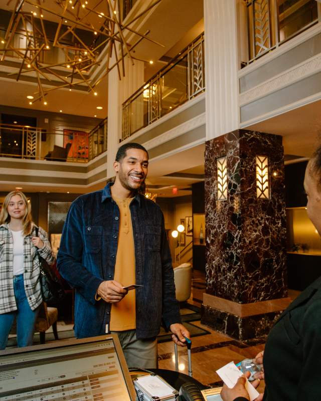 Man checking in to hotel at Hotel LeVeque, Autograph Collection in Columbus