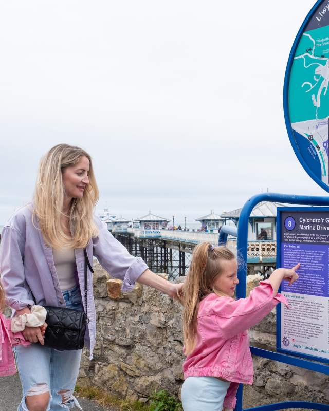 Family looking at Llandudno Heritage trail board