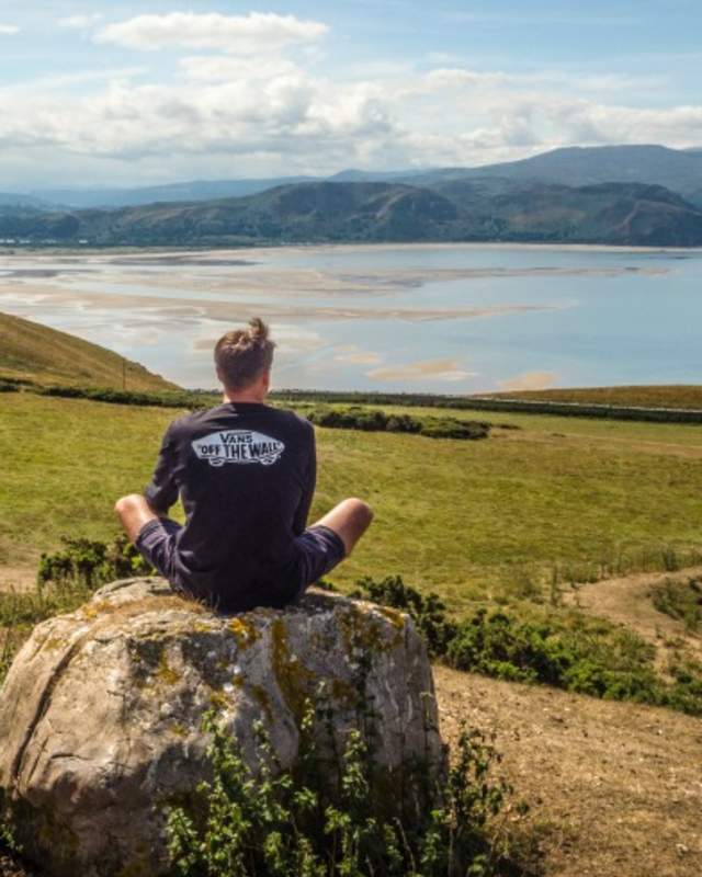 Man sitting on a rock looking out over the landscape