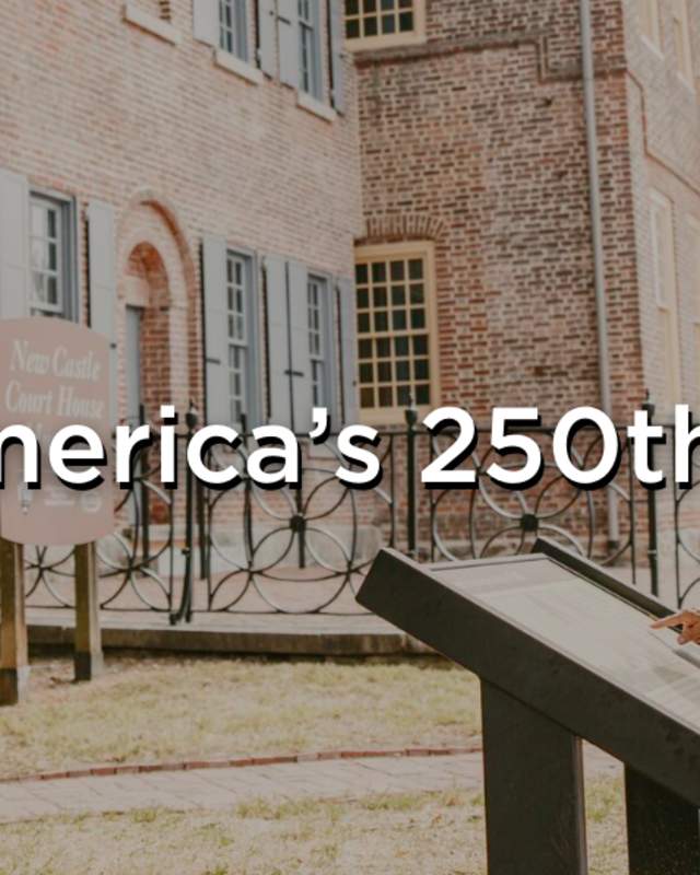 An image reading, "Celebrate America's 250th in Delaware" with a couple reading a plaque in front of the New Castle County Court House.