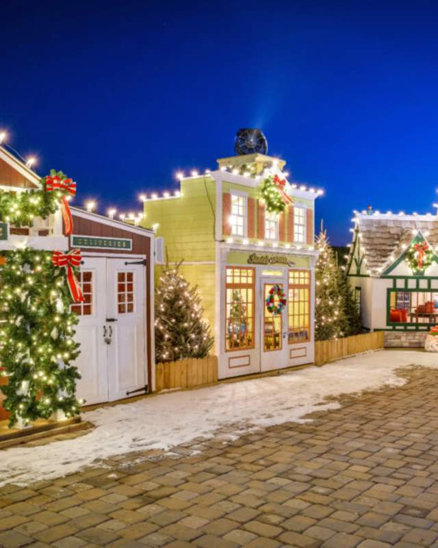 Houses glow with twinkling Christmas lights and other holiday decor.