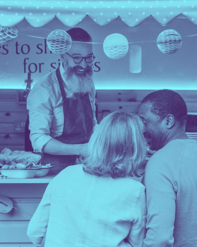 A food truck vendor serving a line of customers.
