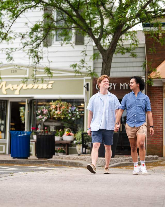 Two men hold hands while walking down Second Street in Lewes, Del.