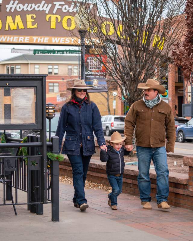 Family walking in downtown Golden wearing Western gear