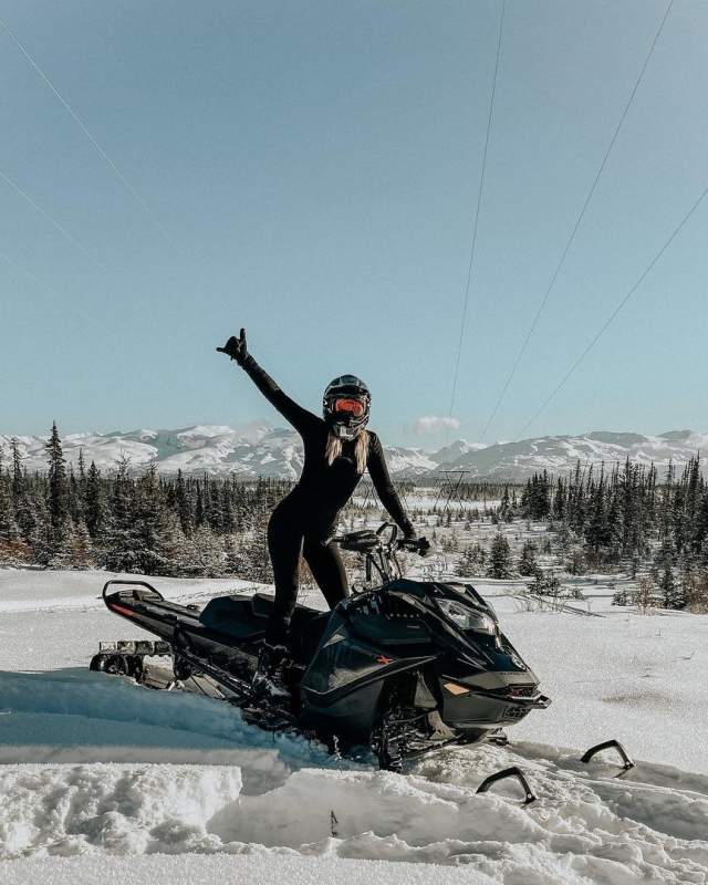 Female snowmobile rider on a snowy trail